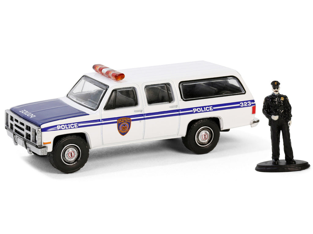 1985 GMC Suburban 2500 "New York City Transit Police Department" White with Blue Stripes and Police Officer Figure "The Hobby Shop" Series 16 1/64 Diecast Model Car by Greenlight-0